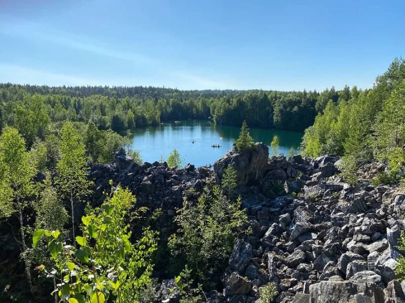 Forest and a small lake viewed from a rocky quarry