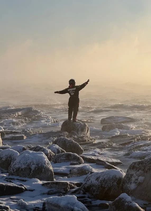 Person on a snowy Arctic coast in strong wind